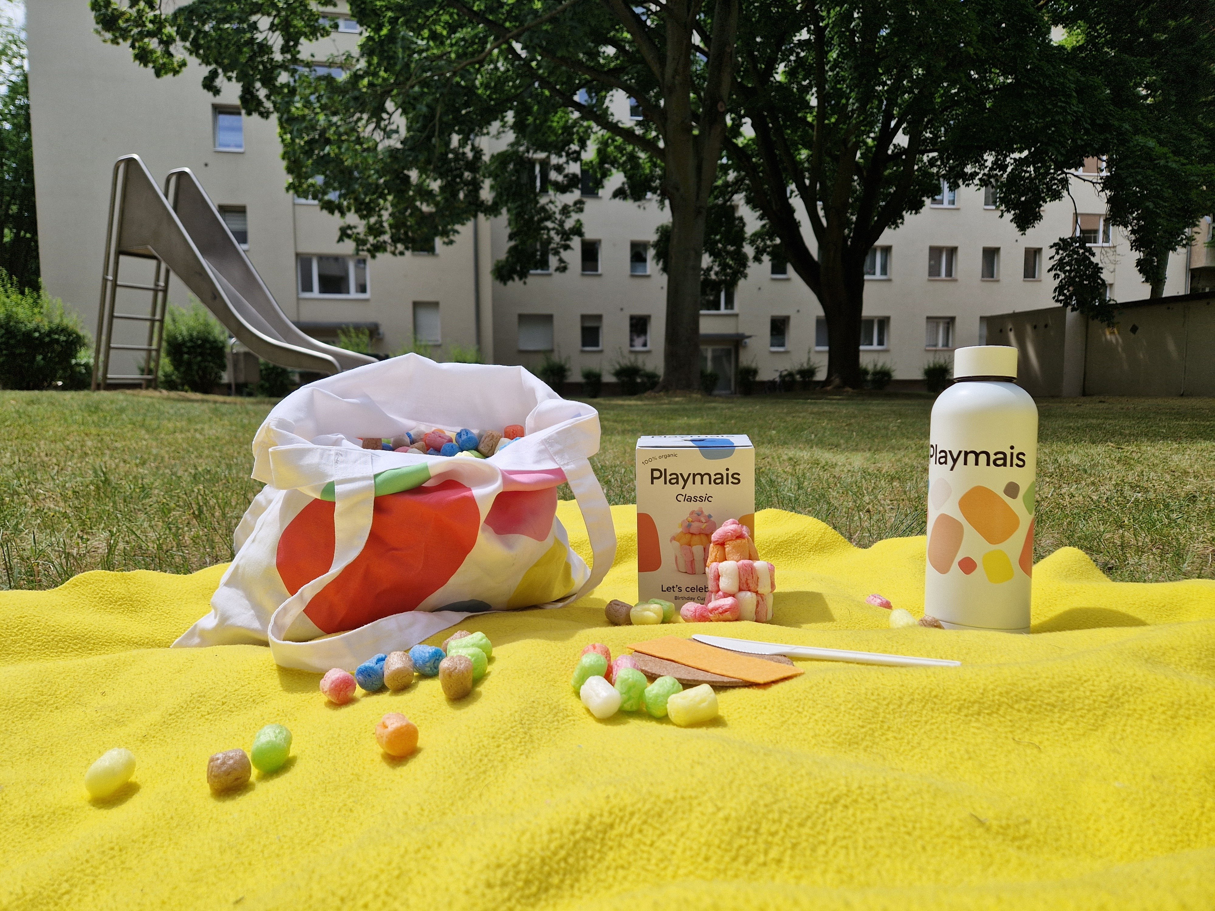 Playmais, Wasser, Bastelmesser, Schwämmchen auf Picknickdecke