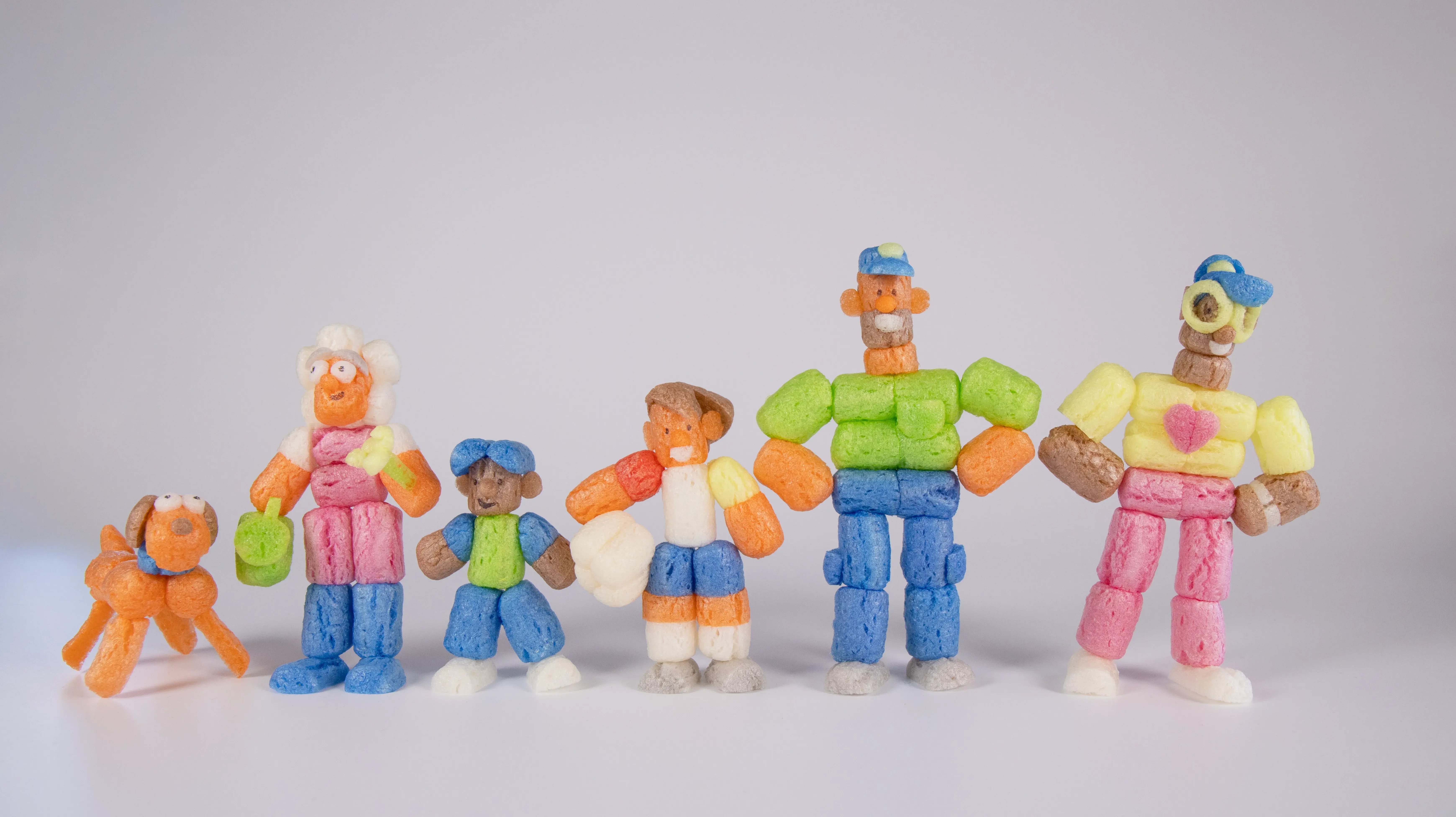 Die ganze Familie aus Playmais in einer Reihe: Hund, Großmutter, zwei Kinder, Vater und Mutter