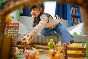 Kind spielt mit Playmais-Figuren auf der Playmais-Farm.