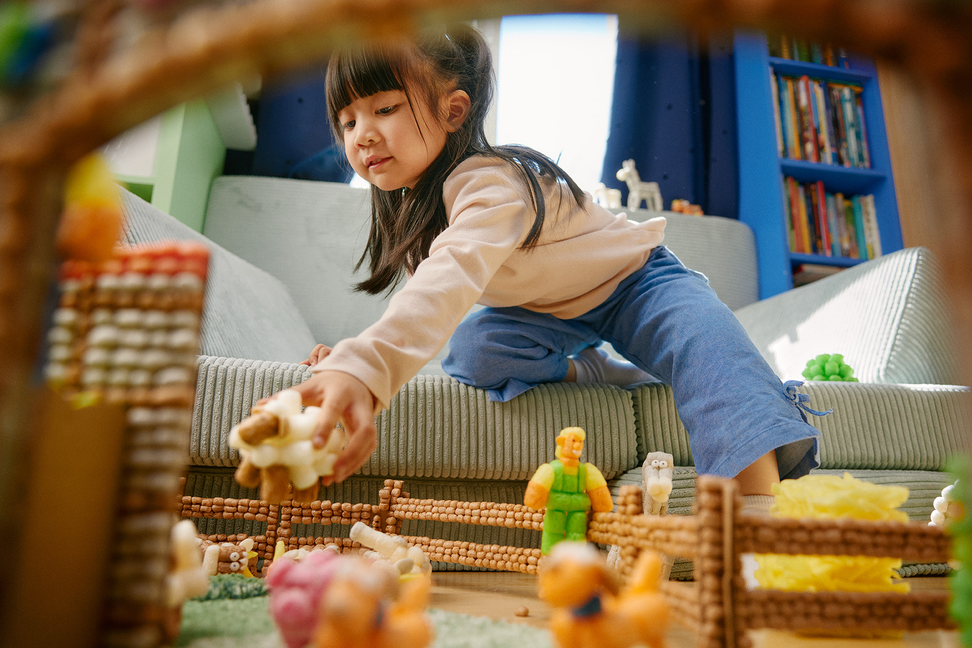 Kindspielt mit Playmais-Figuren auf der Playmais-Farm.